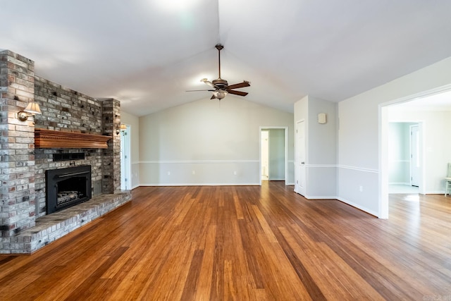 unfurnished living room featuring ceiling fan, a fireplace, vaulted ceiling, and hardwood / wood-style flooring