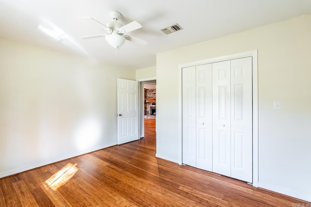 unfurnished bedroom featuring wood-type flooring, a closet, and ceiling fan