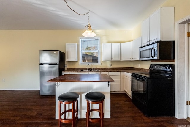 kitchen featuring white cabinets, sink, dark hardwood / wood-style floors, a kitchen island, and stainless steel appliances