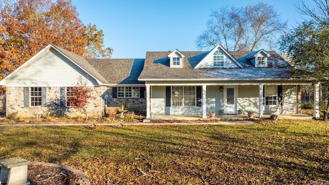 cape cod home with covered porch and a front lawn