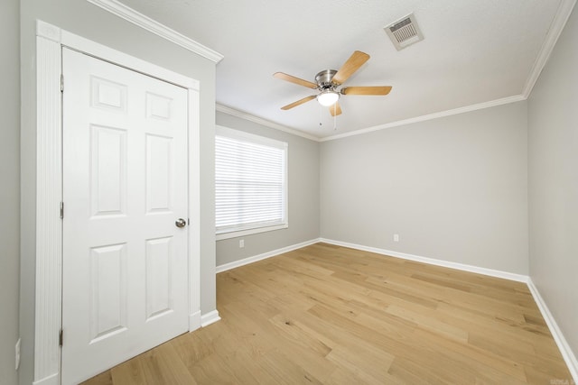 unfurnished room featuring light hardwood / wood-style floors and crown molding