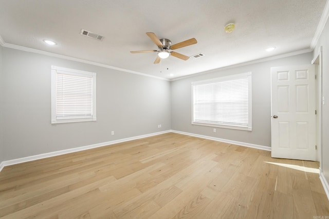 empty room featuring a textured ceiling, light wood-type flooring, ceiling fan, and crown molding