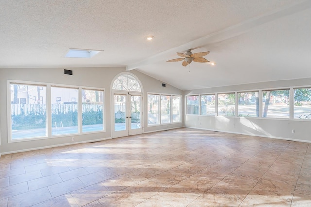 spare room with french doors, a textured ceiling, lofted ceiling with skylight, and ceiling fan