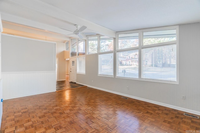 empty room with ceiling fan and dark parquet floors