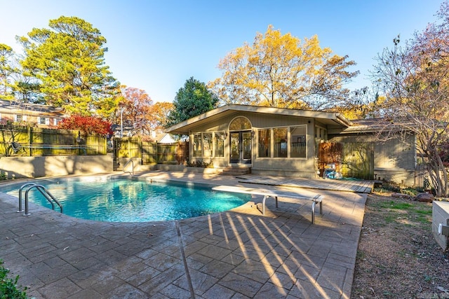 view of swimming pool with a patio area and a sunroom