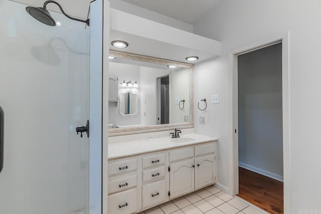 bathroom featuring hardwood / wood-style flooring, vanity, and a tile shower