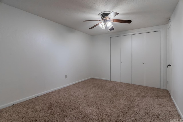 unfurnished bedroom featuring carpet, ceiling fan, a textured ceiling, and a closet