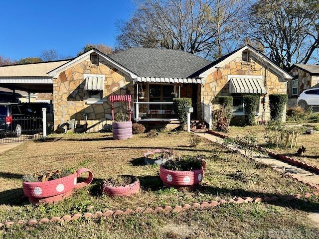 view of front of property featuring a front yard and a carport