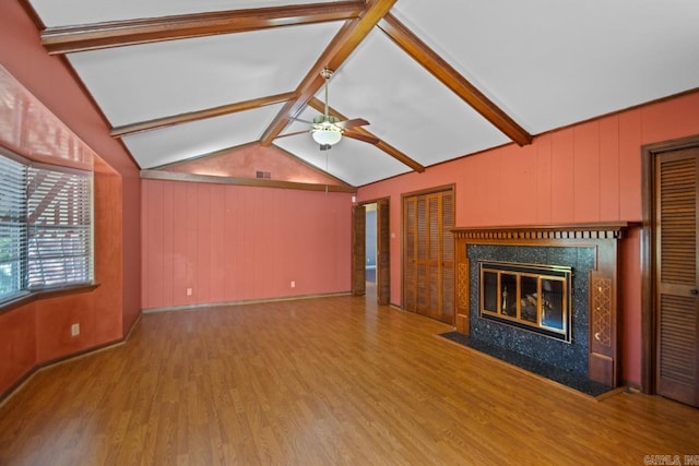 unfurnished living room featuring lofted ceiling with beams, ceiling fan, wood-type flooring, and wood walls