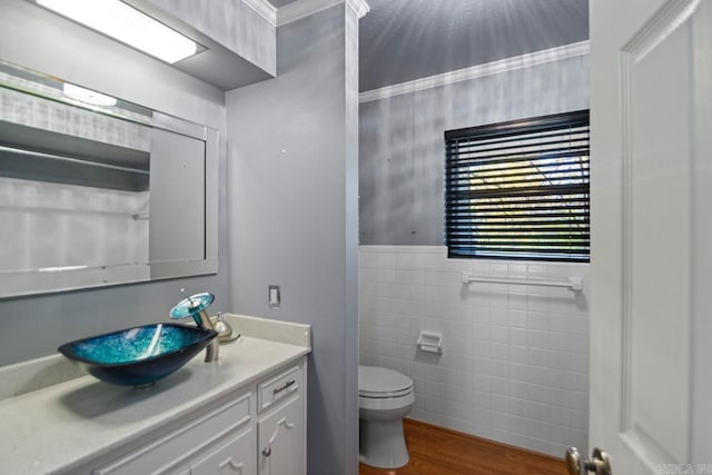 bathroom featuring vanity, crown molding, tile walls, hardwood / wood-style floors, and toilet