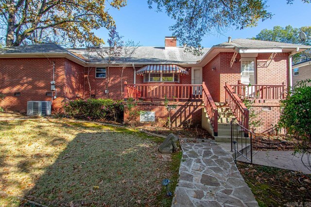 back of property featuring a yard and central AC unit