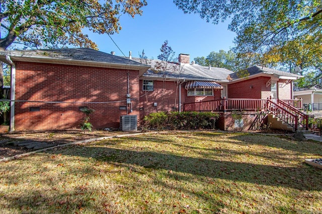 back of property with a lawn, central AC unit, and a wooden deck