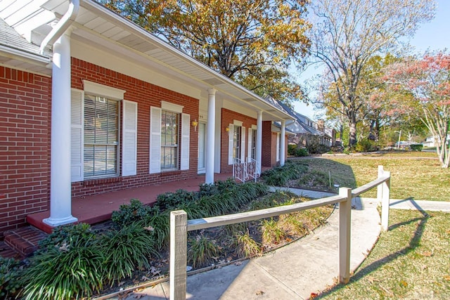 view of side of property with a porch and a lawn