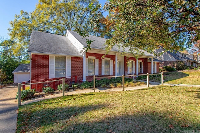 view of front of home with a porch, an outbuilding, a front yard, and a garage