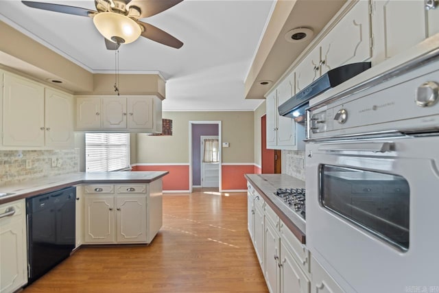 kitchen with white cabinets, ornamental molding, stainless steel appliances, and light hardwood / wood-style floors