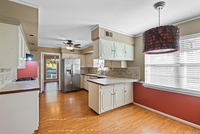 kitchen featuring white cabinetry, hanging light fixtures, tasteful backsplash, kitchen peninsula, and appliances with stainless steel finishes