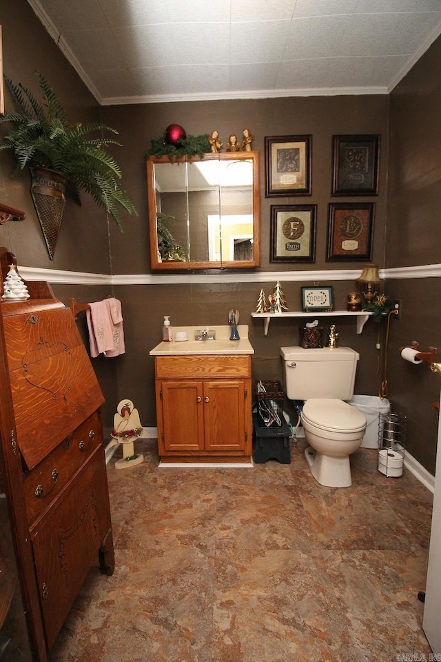 bathroom with vanity, toilet, and ornamental molding
