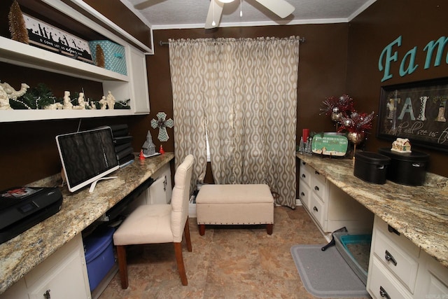 office space with a textured ceiling, built in desk, ceiling fan, and ornamental molding