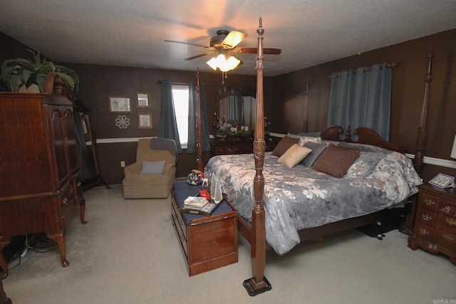 carpeted bedroom with ceiling fan and a textured ceiling