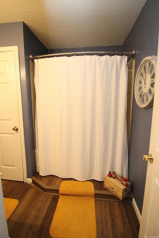 bathroom with hardwood / wood-style flooring and a textured ceiling