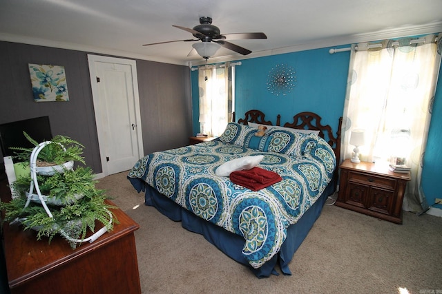 bedroom with carpet, ceiling fan, crown molding, and a closet