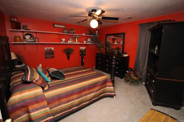 bedroom with ceiling fan, carpet, and a textured ceiling