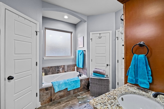 bathroom with tiled bath and vanity