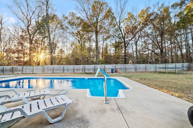 view of swimming pool featuring a trampoline, a patio, and a yard