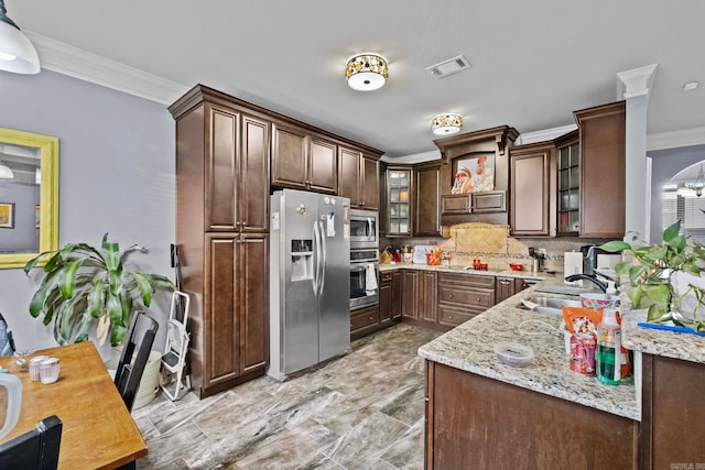 kitchen featuring backsplash, sink, decorative light fixtures, light stone counters, and stainless steel appliances