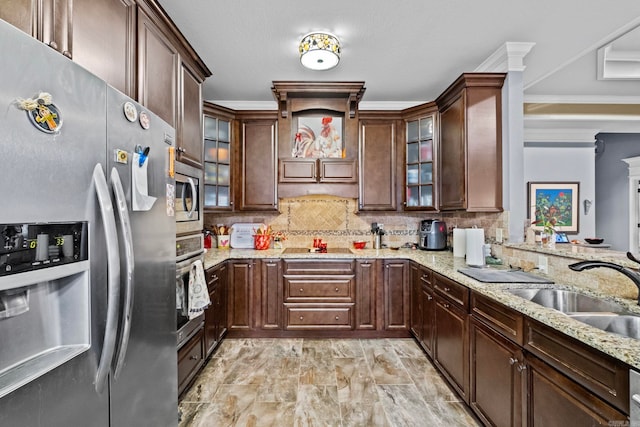 kitchen with light stone countertops, backsplash, ornamental molding, stainless steel appliances, and sink