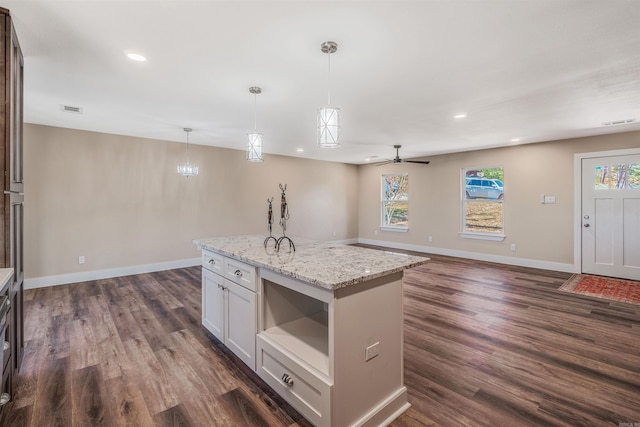 kitchen featuring light stone counters, dark hardwood / wood-style flooring, white cabinets, and a healthy amount of sunlight