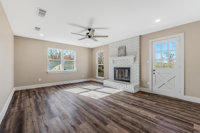 unfurnished living room with dark hardwood / wood-style floors, a brick fireplace, and ceiling fan