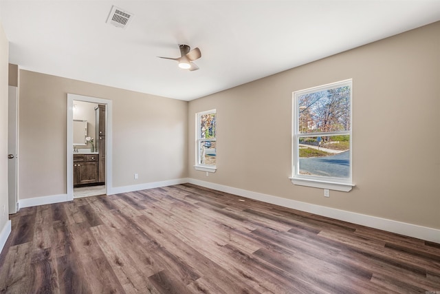 interior space featuring hardwood / wood-style flooring, ceiling fan, and ensuite bath