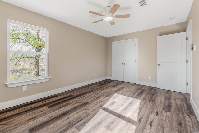 unfurnished bedroom with ceiling fan, a closet, and hardwood / wood-style flooring