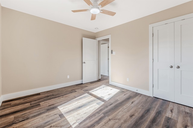 unfurnished bedroom featuring a closet, hardwood / wood-style flooring, and ceiling fan