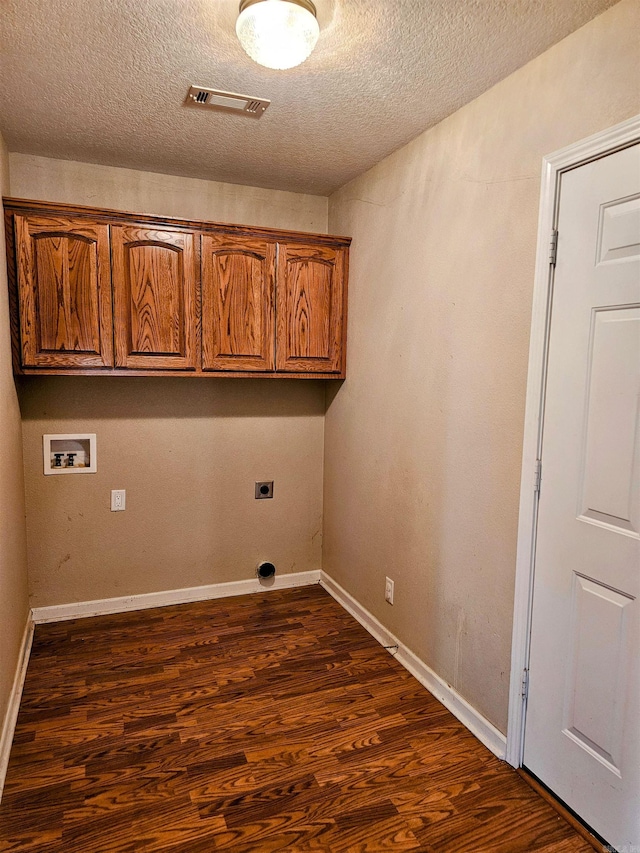 washroom featuring hookup for an electric dryer, hookup for a washing machine, dark hardwood / wood-style flooring, cabinets, and a textured ceiling