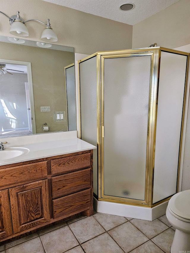 bathroom featuring tile patterned floors, an enclosed shower, a textured ceiling, vanity, and toilet