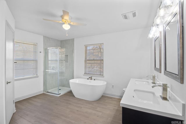 3630 Idlewild Ave, North Little Rock, AR 72116 - bathroom featuring a shower stall, a freestanding bath, double vanity, wood finished floors, and ceiling fan