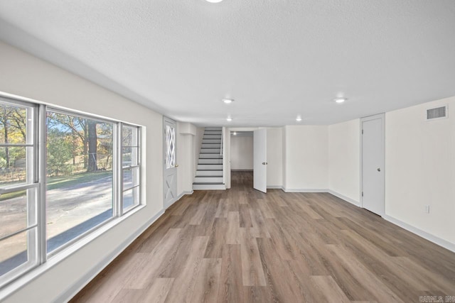 3630 Idlewild Ave, North Little Rock, AR 72116 - unfurnished living room with stairs, wood finished floors, recessed lighting, and a textured ceiling