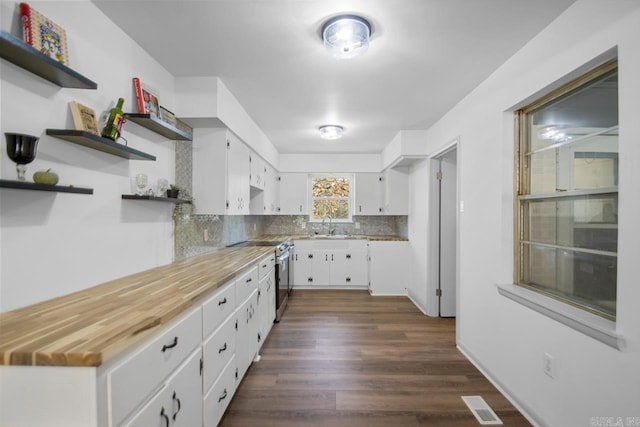 kitchen featuring stainless steel electric stove, white cabinetry, dark hardwood / wood-style flooring, and wooden counters