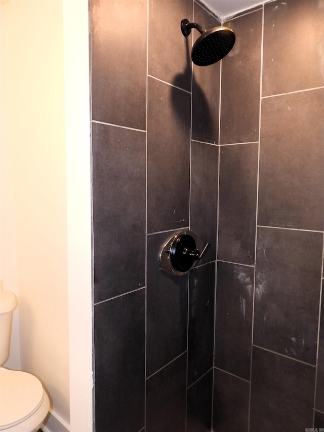 interior space featuring toilet and tiled shower