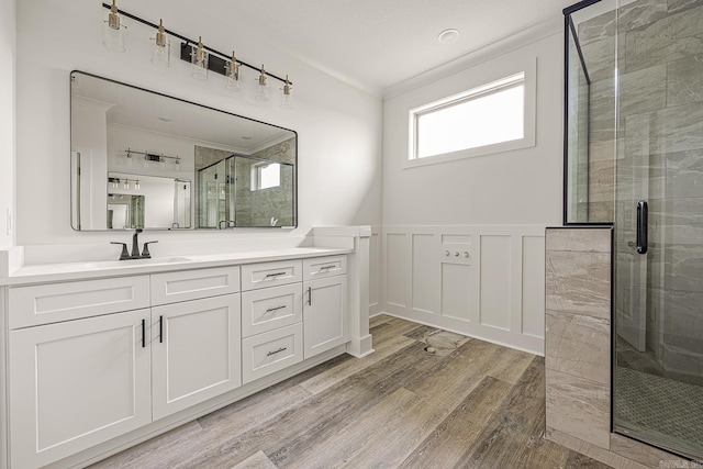 bathroom featuring hardwood / wood-style flooring, vanity, and a shower with door