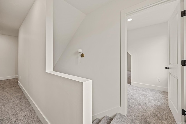 hall with carpet floors and lofted ceiling