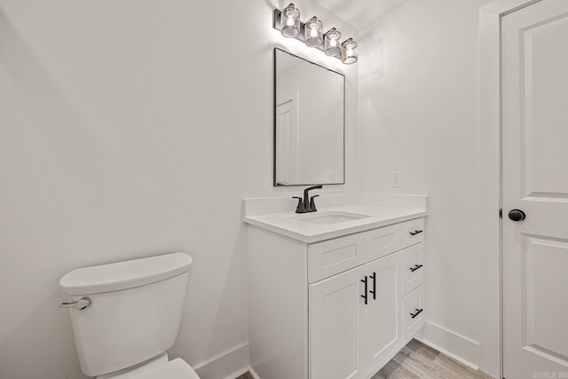 bathroom featuring hardwood / wood-style floors, vanity, and toilet