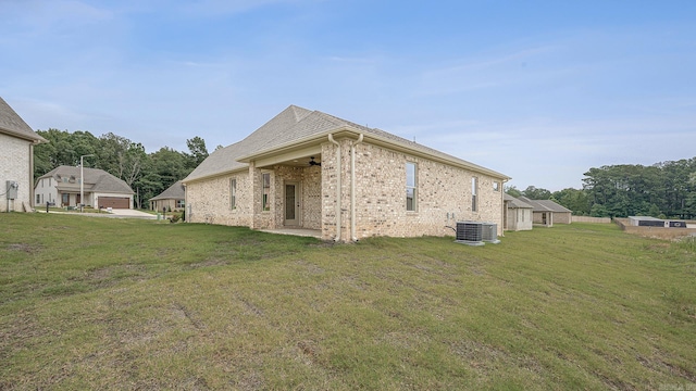 view of side of property featuring a lawn and central air condition unit