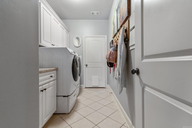 washroom with washer and dryer, light tile patterned flooring, and cabinets