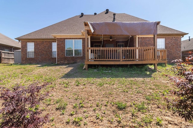 rear view of house featuring a deck, ceiling fan, and a lawn