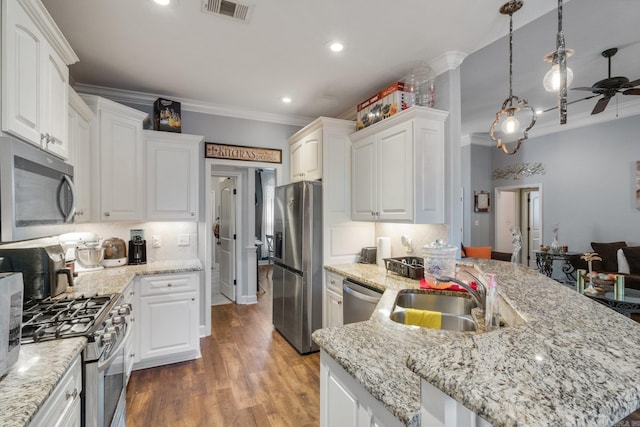 kitchen with ceiling fan, sink, an island with sink, white cabinets, and appliances with stainless steel finishes