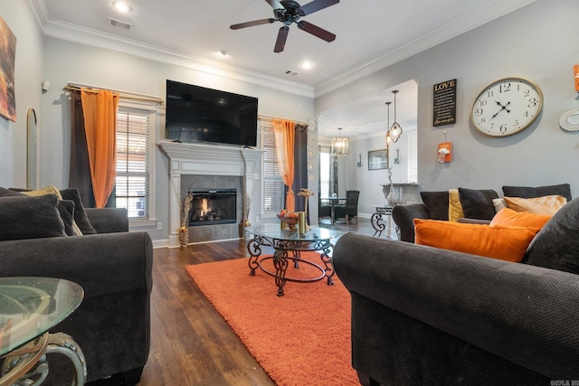 living room featuring a fireplace, ceiling fan, ornamental molding, and dark wood-type flooring