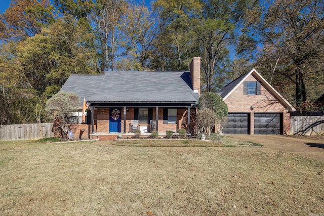 view of front facade with covered porch, a front yard, and a garage